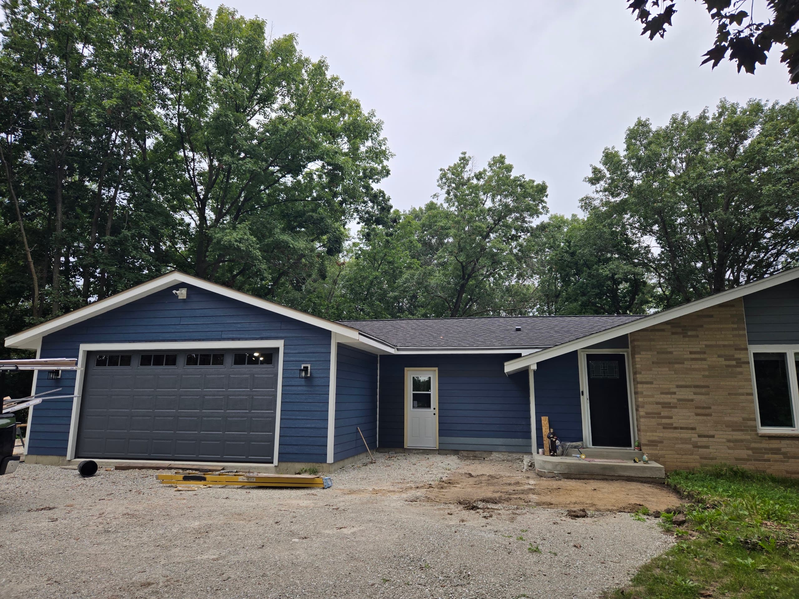 Slate-gray raised-panel garage door on a blue ranch remodel