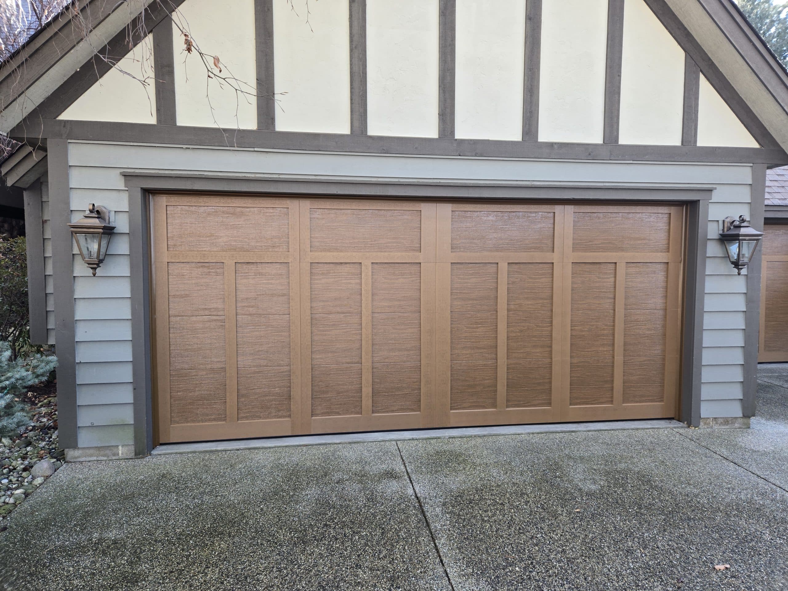 Faux-wood Clopay garage door installed on a Tudor-style home